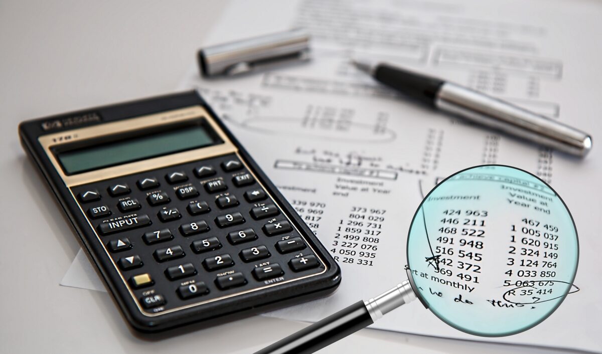 Calculator and financial records to represent financial statement audit terms small business owners in Michigan may want to know