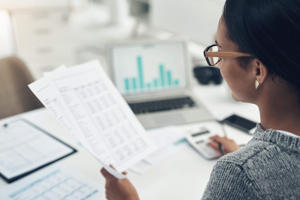 A woman looks at accounting details on a document. Michigan Gov. Gretchen Whitmer recently signed legislation that amends the Michigan Income Tax Act by implementing an elective flow-through entity tax. It may apply to C corporations, LLC, and partnerships.