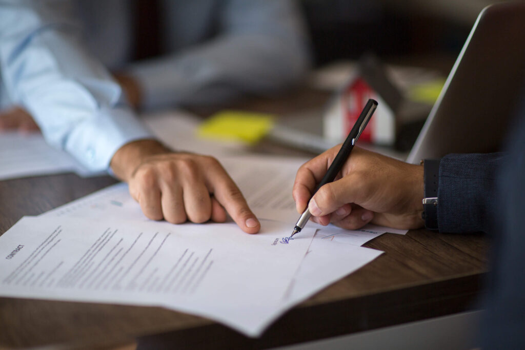 A new business owner signs on the dotted line. New dentists, veterinarians, and other small business owners should understand the differences between C corporations, S corporations, LLCs, partnerships, and sole proprietorships before opening their doors.