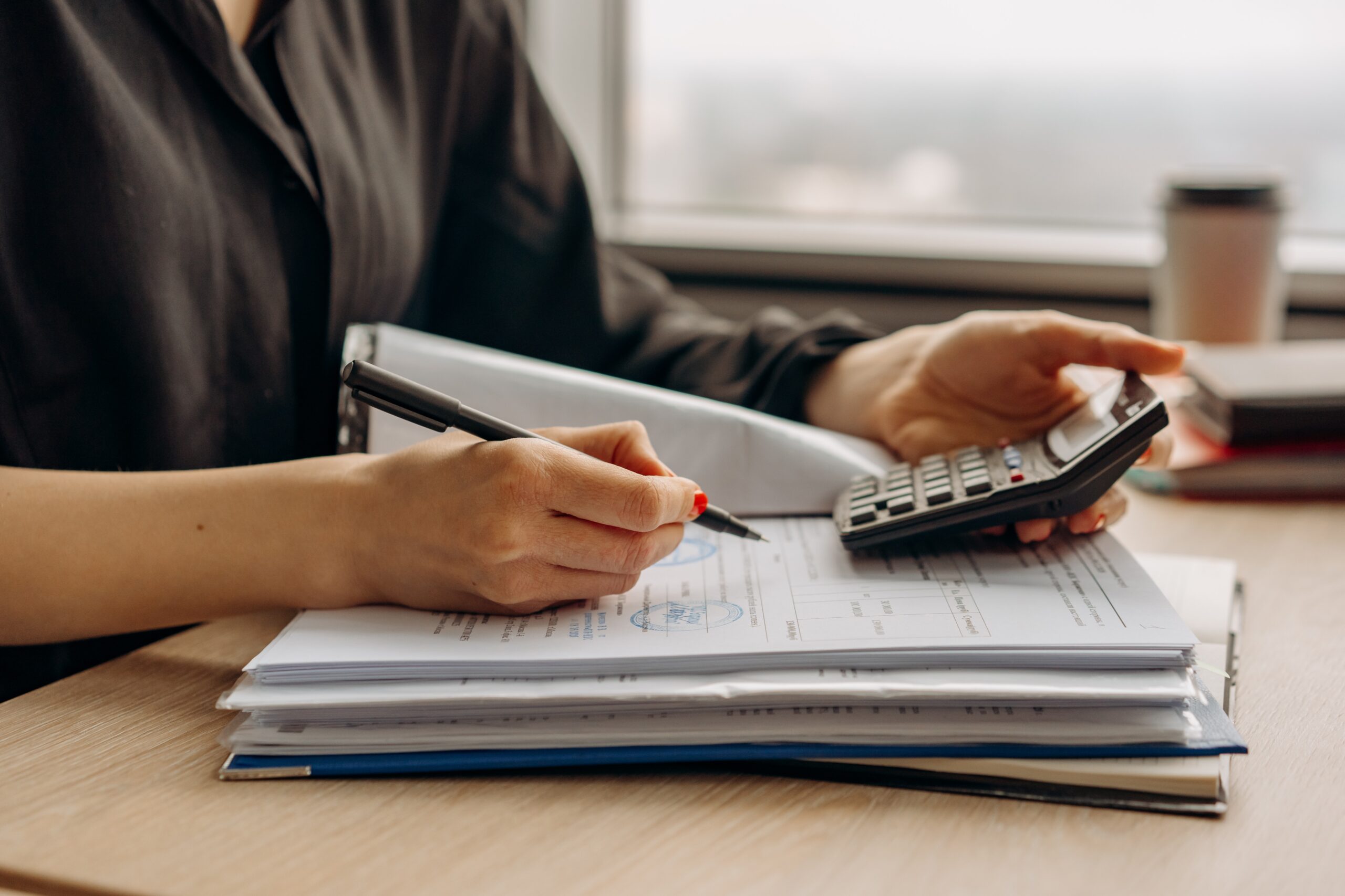 Best business accountant writing on a notepad with a calculator